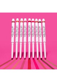 Negen witte lippenpotloodtubes met het label "Lip Injection" uitgelijnd boven bijbehorende kleurstalen in verschillende roze, rode en bruine tinten op een roze achtergrond.