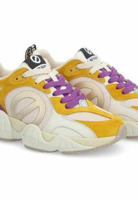Sneaker con una toma gialla in suede, dettagli in rete, lacci viola e suola beige; presenta un accento con il logo sul lato e un'etichetta nera sulla linguetta.