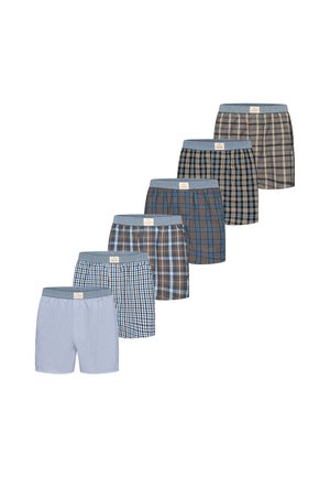 Seks par herreboxershorts i forskellige blå og brune tern- og stribemønstre, arrangeret i en diagonal række på en hvid baggrund.