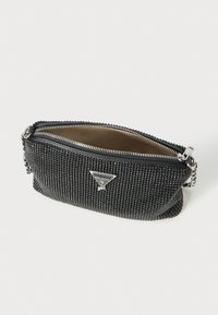 Borsa da polso Guess nera con embellishments in strass, tracolla in catena argentata e zipper parzialmente aperta che mostra l'interno beige.