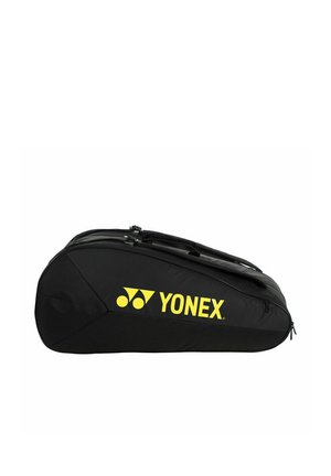 Sac de sport noir Yonex avec logo jaune, conçu pour transporter des raquettes, doté de plusieurs compartiments zippés et d'une poignée de transport.