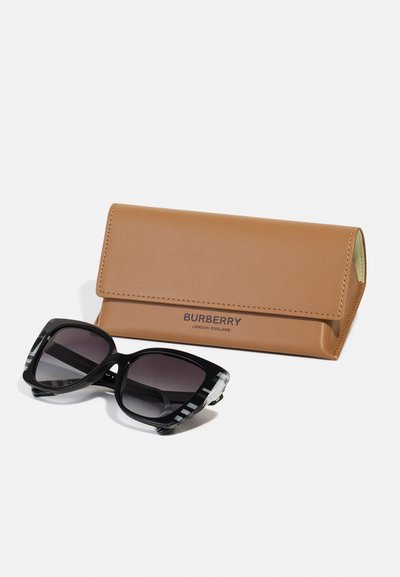 Mustad mustangad, millel on paks raam ja mille varrukad on kaunistatud ruuduline muster, asetatud pruunist nahkast karbile, millel on silt "Burberry."