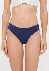 Marineblauwe ondergoed met een gladde textuur en minimalistisch ontwerp. Kenmerkt zich door een lage taille en een subtiele merklogo aan de zijkant.