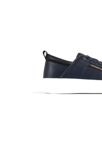 Sneaker in pelle blu navy con suola in gomma bianca, dotata di un linguetta e accento del logo in oro. Texture liscia con elementi di design minimi.