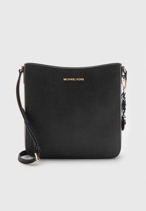 Black Michael Kors crossbody bag with gold logo, adjustable strap, and textured finish on a light background.