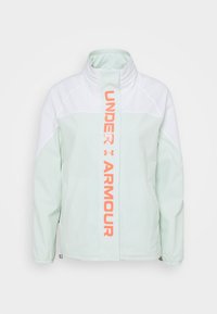 Jasnozielona i biała kurtka z wysokim kołnierzem oraz osłoną zamka z pionowym pomarańczowym logo Under Armour.