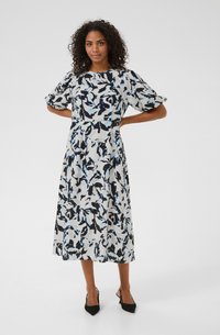 Kesimpulan tengah dengan pola bunga berwarna hitam, putih, dan biru. Dilengkapi dengan lengan menggelembung dan bodice yang pas, terbuat dari kain yang lembut.