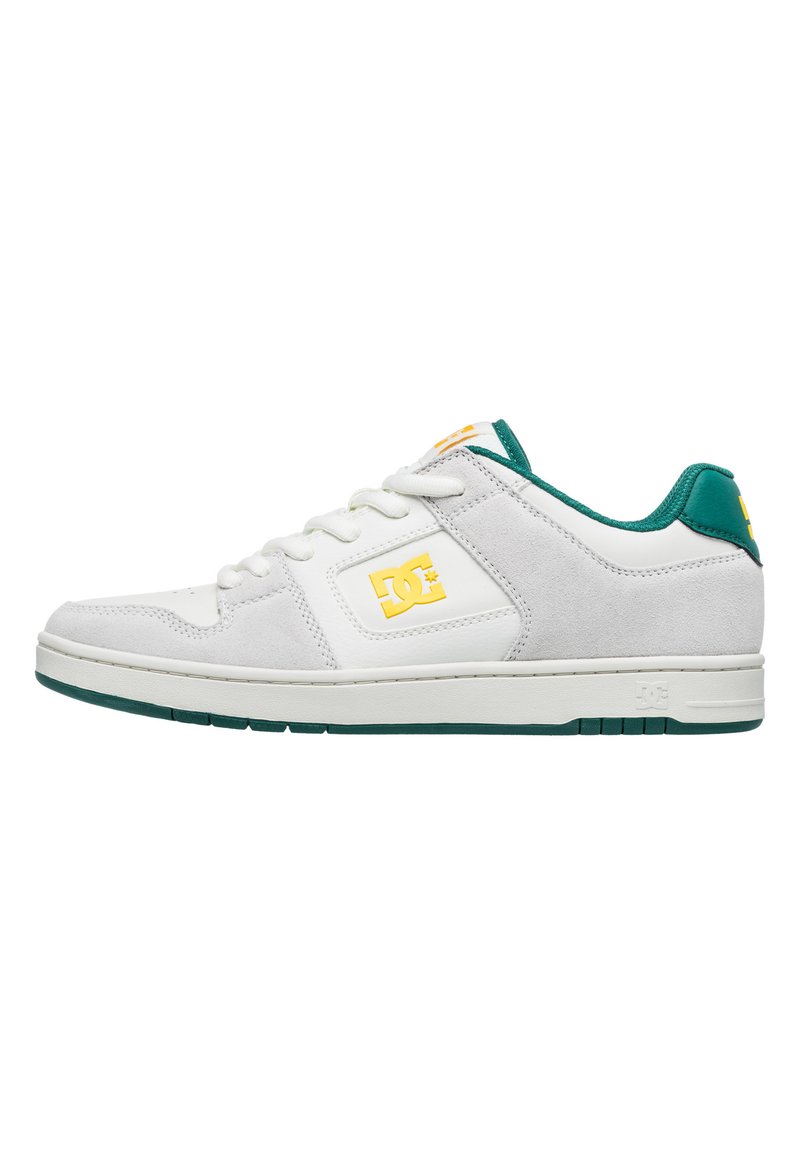 White and grey sneaker with a suede and leather upper, green accents on the heel and tongue, and yellow logo. Flat rubber sole.