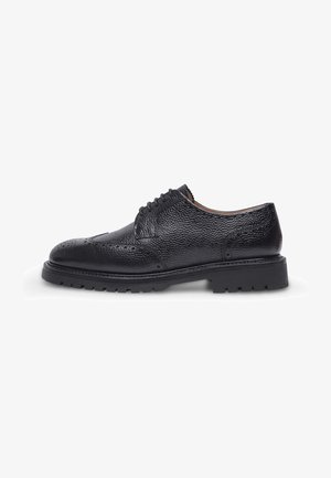 Scarpa oxford di pelle nera con finitura testurizzata, caratterizzata da una punta arrotondata, una chiusura con lacci e una suola in gomma spessa con battistrada.