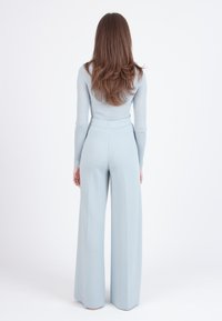 Lichtblauwe geribde lange mouw top gecombineerd met bijpassende wijde broek, met een aangesloten taille en een zachte textuur.