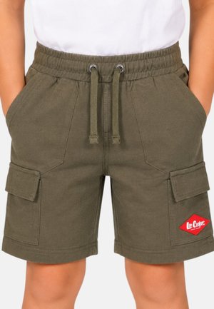 Enfant portant un short cargo vert olive avec poches avant, ceinture à cordon et écusson rouge Lee Cooper, les mains dans les poches, chemise blanche visible.