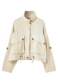 Veste courte beige avec un col montant, deux poches avant et des boutons en bois. Tissu texturé avec cordons de serrage à l'ourlet pour un ajustement.