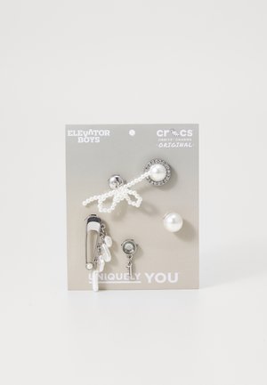 Pet pet ročaji za obutev z dekorativnimi značkami, ki vključujejo srebrno strojno opremo, bisere in sijoč dizajn na sivi podlagi, označeni z "Edinstveno ti".