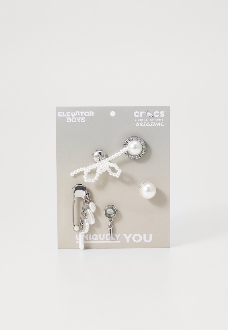 Cinq pendentifs décoratifs pour chaussures, comportant du matériel en acier inoxydable, des perles et un design en perles sur un fond gris, étiquetés "Uniquement Vous."