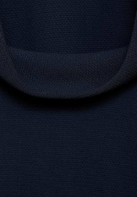 Acercamiento de una tela texturizada en un azul marino oscuro con un escote suave, destacando el tejido y el color del material.
