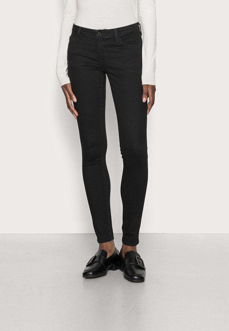 Pantalones vaqueros ajustados negros con cintura alta, que cuentan con cinco bolsillos, cierre de botón metálico y una tela suave y elástica.