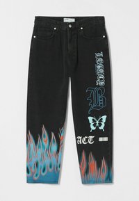Černé džíny s denimem a plamenovým designem v modré a oranžové na spodní části, s bílým textem a grafikou na přední straně.