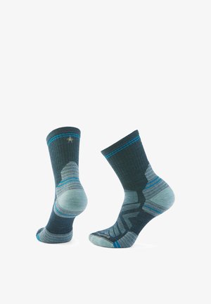 Donkerblauwe sokken met lichtblauwe accenten, voorzien van een geribde boord en een gestreept patroon. Gemaakt van een zachte, gestructureerde stof voor comfort.