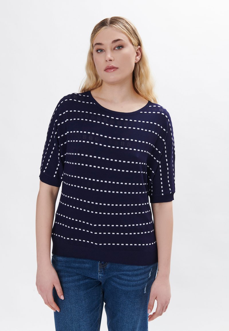 Maglia di colore blu navy a maglia, con strisce orizzontali bianche e maniche corte, caratterizzata da un colletto rotondo e un dettagliato texture sulle maniche.