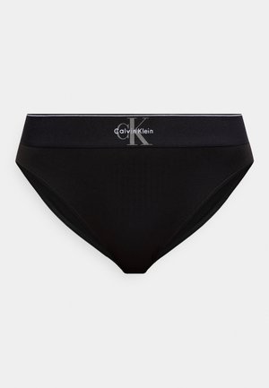 Fekete Calvin Klein alsónadrág széles derékpánttal, amelynek középső részén szürke "cK Calvin Klein" logó látható.