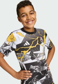 Kortærmet t-shirt med grafik i sort, hvid og gul; indeholder tegneseriestil illustrationer og lyn-effekter. Rund halsudskæring, atletisk pasform.