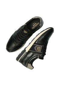 Schwarze Ledersneaker mit strukturiertem Finish, ausgestattet mit einer weißen Zwischensohle, Schnürdesign und einem Logo-Highlight an der Seite.