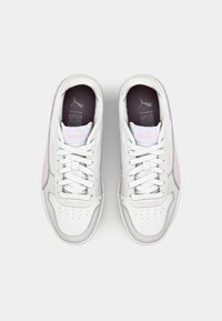 White athletic sneakers with pink accents, textured leather upper, perforated toe box, and flat white laces. Puma logo on tongue and side.