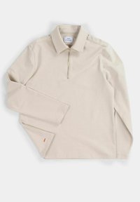Polo beige a maniche lunghe con colletto a zip, spacchi laterali e un piccolo logo arancione all'orlo, realizzato in un tessuto morbido.