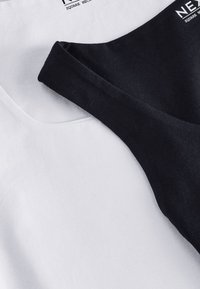 Čierne a biele tielka s štvorcovým výstrihom, vyrobené z bavlny. Čierne tielko má hladkú textúru, zatiaľ čo biele pôsobí mäkko.