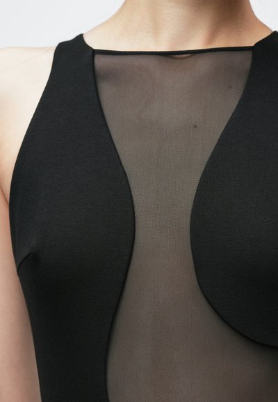 Robe noire ajustée avec un panneau en mesh transparent au centre, un décolleté structuré et une texture lisse sur le corsage.