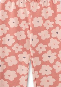 Rosa Leggings mit floralem Muster, großen hellrosanen Blumen und kleinen dunkelblauen Akzenten. Weiche, dehnbare Stofftextur.