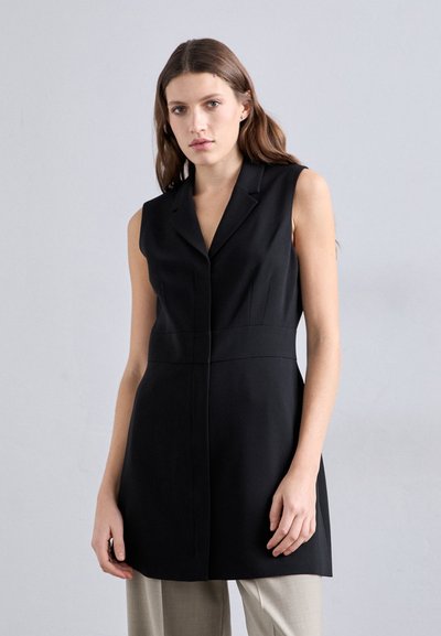 Robe noire sans manches avec un col cranté, coupe structurée et fermeture à un bouton, fabriquée dans un tissu lisse avec un design minimaliste.