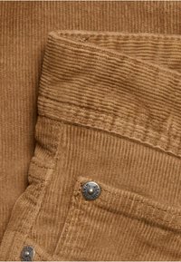 Brunt kordfløjlsstof med lodrette ribber, med en syet talje og metalknapdetalje mærket "DENIM."