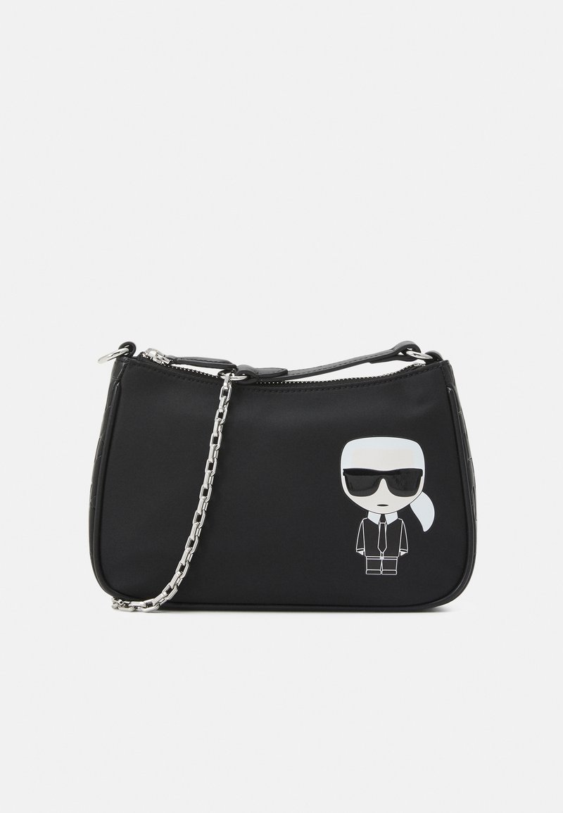 Sac à main synthétique noir avec une bandoulière en chaîne argentée et un graphique de personnage de dessin animé en costume avec des lunettes de soleil. Texture lisse. Fermeture éclair.