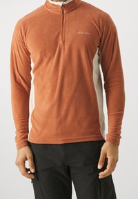 Polarowy sweter, pomarańczowe body z kremowymi panelami bocznymi, zamek błyskawiczny ¼, długie rękawy, miękka tekstura, logo na klatce piersiowej.