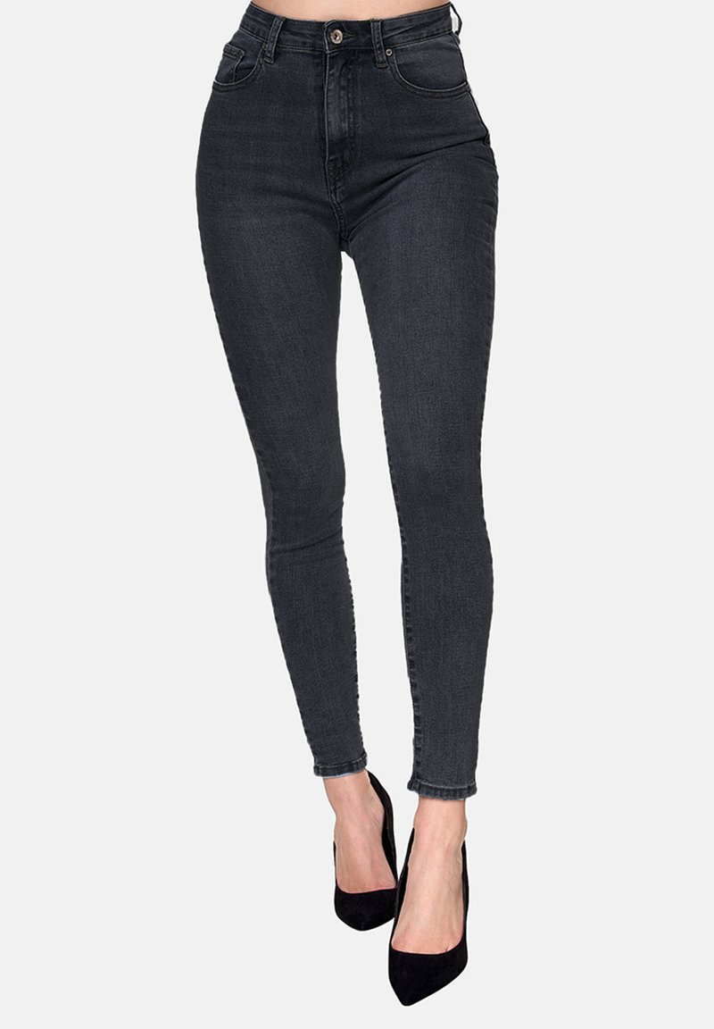Jeans skinny de tiro alto en denim gris oscuro, con un ajuste elegante, diseño de cinco bolsillos y detalles de costura sutiles, combinados con tacones negros.