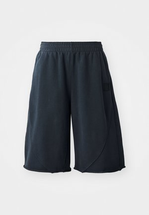 Black athletic shorts made of soft fabric, featuring an elastic waistband and a logo patch on the side. Smooth texture with a relaxed fit.