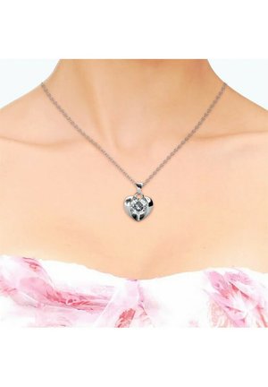 Collana con pendente a forma di cuore in argento, caratterizzata da una pietra trasparente centrale e appesa a una delicata catena. Il design è lucido con bordi lisci.
