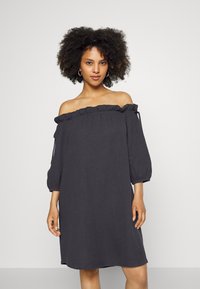Vestido cinza escuro, sem mangas, com decote ondulado, mangas três quartos e tecido texturizado. Silhueta em A e ajuste solto.