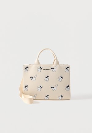 Creme farvet mulepose med illustrationer af kat med sorte solbriller og øverste håndtag, med tekstlogoet "KARL LAGERFELD".