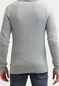 Gray knitted sweater with a textured design, ribbed cuffs and hem, and a collar. The back view shows the seamless, fitted construction.