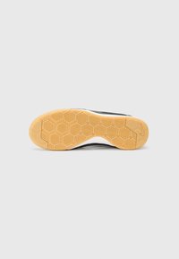 Nike-Schuhe mit schwarzem Obermaterial, weißer Mittelsohle und Sohle aus Gummi mit einem Wabenmuster für besseren Grip. Der Schuh wirkt niedrig geschnitten und schlank.