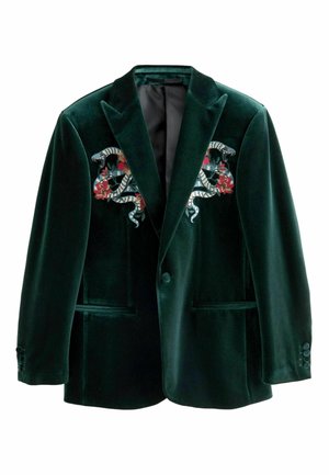 Zaļš samta žakets ar čūsku un ziedu izšuvumu uz krūškurvja. Aprīkots ar diviem pogu aizdari un divām priekšējām kabatām. Gluda tekstūra.