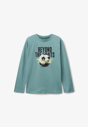 Licht teal, langmouw t-shirt van zacht materiaal met een zwart-witte afbeelding van een voetbal en de tekst "BEYOND THE LIMITS" in vette letters.