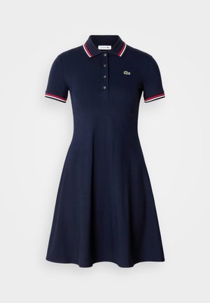 Abito polo blu realizzato in cotone, con gonna svasata, maniche corte a righe rosse e bianche e logo ricamato verde.