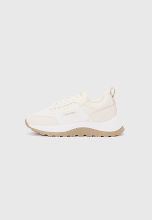 Sneakers Calvin Klein w kolorze kremowym i beżowym z teksturowanym materiałem, masywną podeszwą, sznurowaniem oraz pętelką przy pięcie ułatwiającą zakładanie.