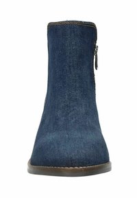 Denim enkellaars met een taps toelopende vorm, donkerblauwe kleur, rits aan de zijkant en een bruine zool. Materiaal lijkt soepel en duurzaam.