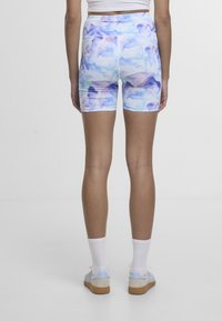 Flerfargede shorts i blå og lilla abstrakte mønstre, laget av elastisk materiale, med høy midje og tettsittende design.