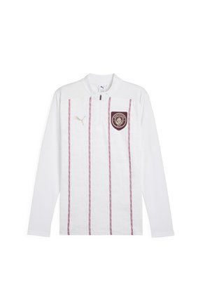 Maillot d'entraînement de football à manches longues blanc avec col zip, présentant des rayures verticales bordeaux et le logo de Manchester City sur la poitrine gauche. Accents du logo Puma doré.