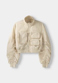 Beige cropped jacket with ruched long sleeves, ribbed cuffs and hem, front zipper, and three rectangular zippered pockets on the chest.